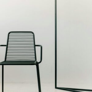 A sleek black metal chair captured in a minimalist studio shot with white background.